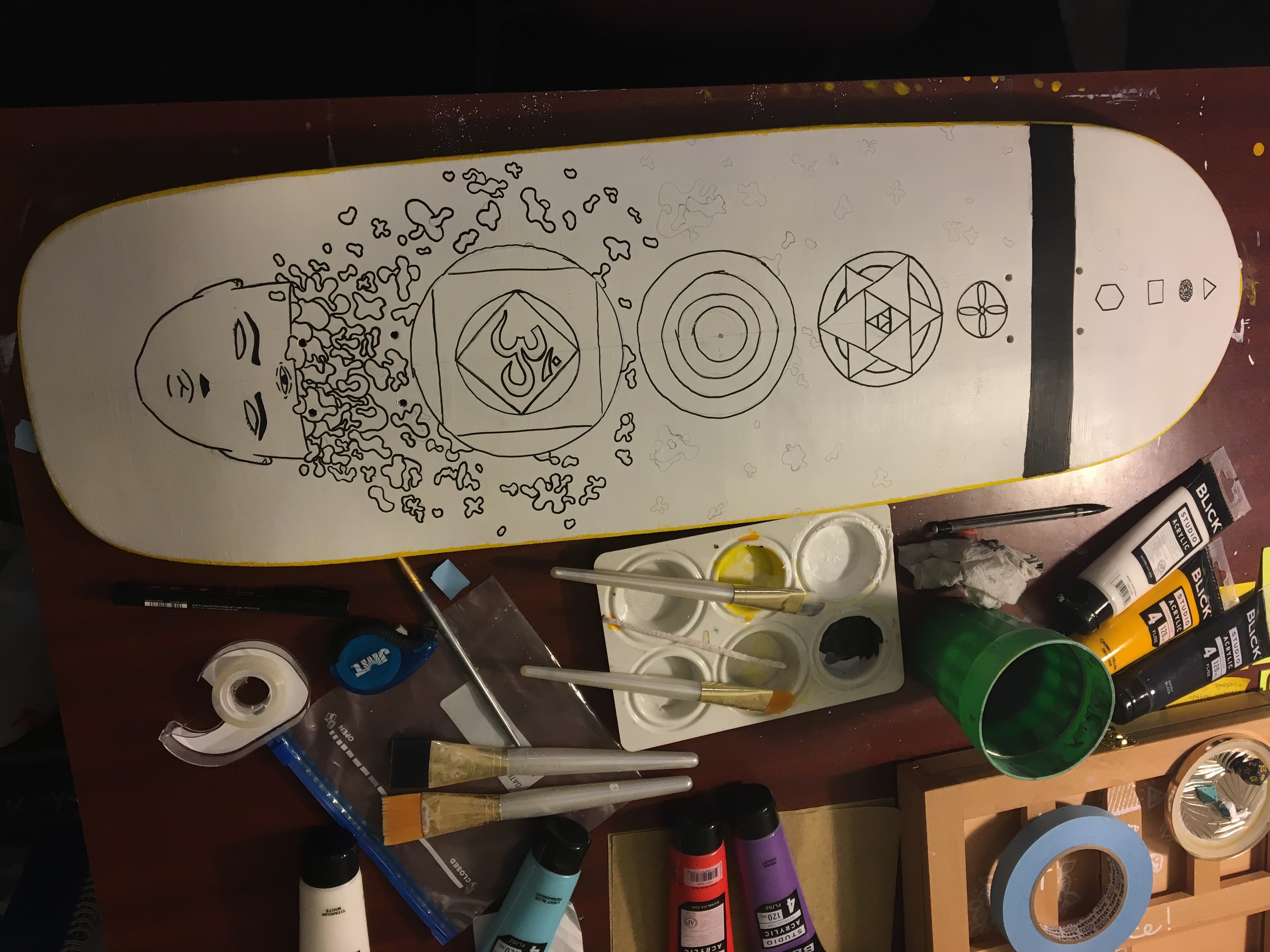lines in black paint pen on skateboard now depict geomteric shapes, surreal third eye head with organic shapes pouring out